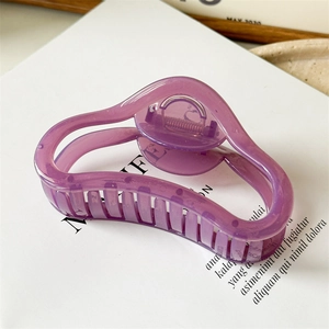 Macro detail of purple jelly curved claw clip showing streamline wave design and metal spring