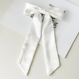 Elegante fiocco per capelli in raso bianco con nastri lunghi su scheda di supporto