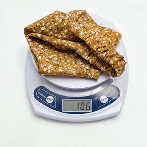 Floral elastic headband shown on a digital scale weighing 10.6 grams for lightweight feel