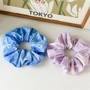 Detail of blue and purple tie-dye fabric scrunchies with soft cotton texture