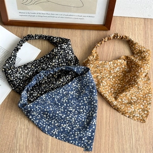 Macro shot of three floral print elastic bandanas on a vintage wooden background