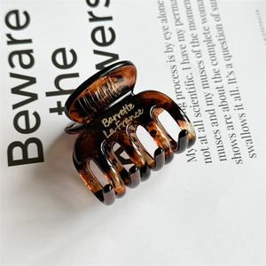 Detailed macro view of amber tortoiseshell hair claw with gold Barrette La France text