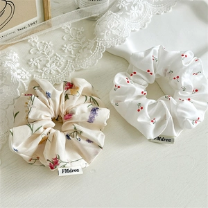 Fresh floral scrunchies with cherry patterns on a minimalist wood texture background