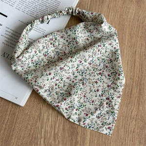 Detailed macro view of the floral triangle hair scarf with red buds and elastic band