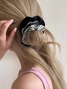 Detail of high-elasticity hair scrunchie with navy style stripes and CHANGE lettering