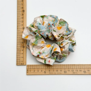 Floral print scrunchie with soft ruffled edges and watercolor patterns measuring 12cm