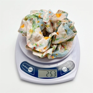 Floral print scrunchie made of premium fabric displayed on a scale showing 25.3g weight