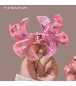 Detailed macro view of pink and purple marble texture butterfly hair claw clip with gold spring