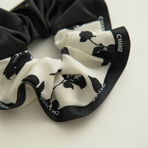 Detail of nautical scrunchie fabric with floral patterns and 'CHANGE' woven label