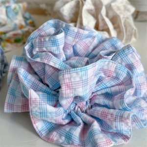 Close-up of a blue and white checkered oversized scrunchie with soft pleated cotton fabric
