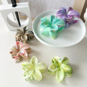 Detailed view of colorful acetate flower hair claws with marble texture in various colors