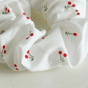 Retro scrunchie with red cherry print on white fabric for elegant hair styling
