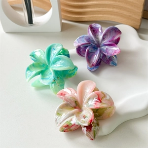 Detailed macro view of colorful acetate flower hair claws with marble texture finish