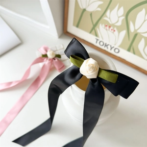 Elegant handmade satin bow hair clips with rose decor and long ribbons in pink and black