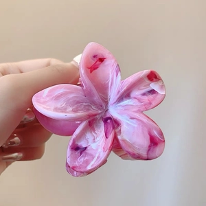 Detail of pink and white marble texture on floral hair claw clip with acetate finish
