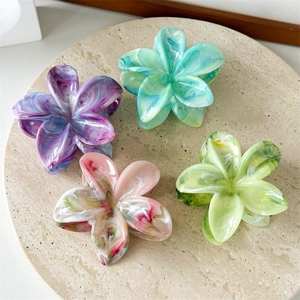 Set of four flower-shaped marble texture hair claws in purple pink blue and green colors