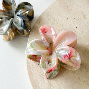 Detail of floral claw clips with marble texture in pink, white, and black finishes