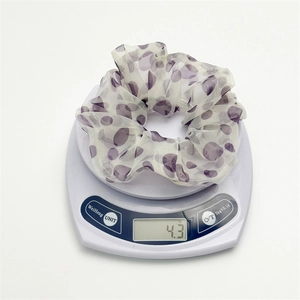 Elastico scrunchie a pois viola in organza su bilancia che mostra il peso di 4,3g