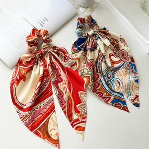 Detailed shot of vintage paisley ponytail scarves in red and blue silk textures