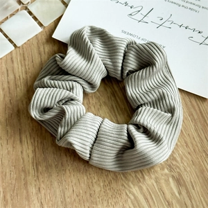 Detailed macro view of the grey striped elastic scrunchie on a natural wooden background