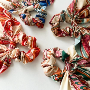 Detail of four vintage floral print hair scrunchies with long ribbons on white background