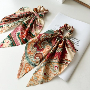 Detailed macro shot of vintage patterned silk scrunchies with long streamers on a magazine