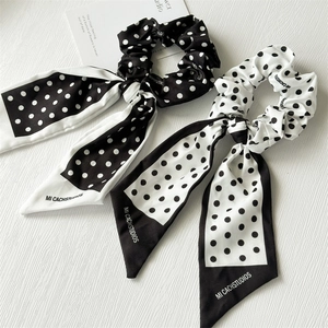 Chouchous à nœud papillon à pois noirs et blancs sur une surface texturée élégante