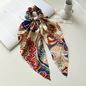 Detail of bohemian satin ponytail scarf with vibrant patterns on white background