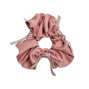 Pink satin scrunchie with black and white polka dot bows on a clean white background