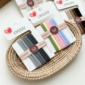 Macro shot of assorted seamless elastic hair ties sets displayed in a woven tray