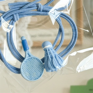 Gros plan d'un chouchou sport bleu avec pendentifs raquette de badminton et volant