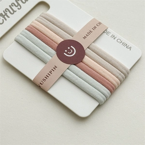 Detailed macro view of five high-elastic seamless knit hair ties in earthy neutral tones