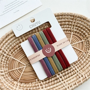 Close-up of high-elasticity colorful hair ties in a rustic basket with ins-style card
