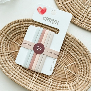 Close-up of five seamless high-elastic hair ties in soft Morandi colors on a card