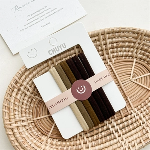 Detailed close-up of 6-pack elastic hair ties in gradient earthy tones on display card