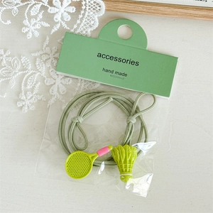 Détail de breloques raquette et volant de badminton sur des élastiques à cheveux verts