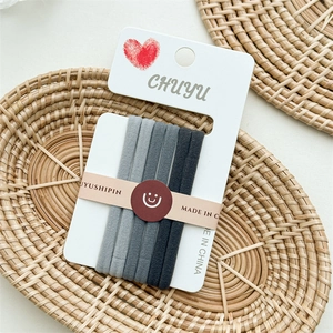Detailed view of 5-pack seamless grey gradient hair ties on a minimalist display card