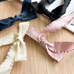 Set of four pleated fabric bow hair clips in navy, black, cream and pink silk texture
