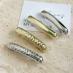 Set of four geometric metal hair clips in gold and silver with smooth and hammered textures