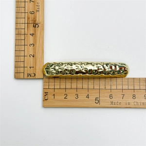 Minimalist gold geometric hair clip with irregular hammered texture on white background