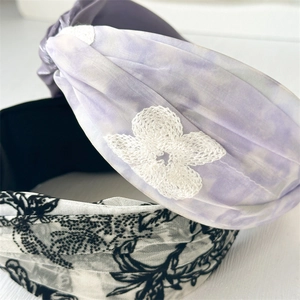 Detail of wide twist headband set with lilac tie-dye fabric and delicate white lace flowers