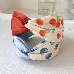 Floral knot headband featuring contrast patterns and elegant wide-edge fabric design
