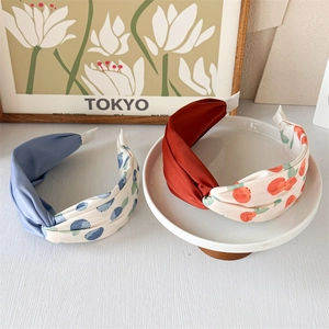 Detail of twisted floral headbands in blue and orange prints with elastic back straps
