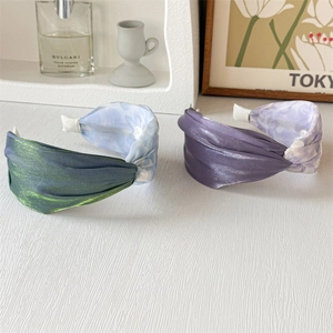 Detail of twisted floral headbands in satin fabric with lace accents and soft colors
