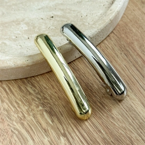 Macro shot of minimalist gold and silver metal hair clips with a polished mirror finish
