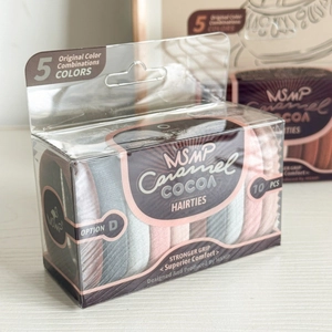 Close-up of ten high-elastic hair ties in coffee tones inside a clear storage box