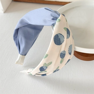 Detail of color-block headband with blue berry print and silk-like knot texture