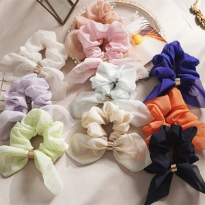 Présentation à plat de chouchous élégants avec boucles dorées en divers tons pastel
