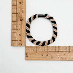 Elastische Spiral-Haargummis in Schwarz und Braun mit Größenmessung auf weißem Hintergrund