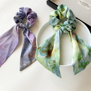 Artistic oil painting style silk scrunchies with long ribbons on a white ceramic plate